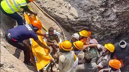 SDRF and other emergency services personnel rescue a two-year old boy who fell into a borewell in Lachayan village, in Vijayapura, Karnataka, on Thursday. (PTI)
