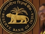 A woman walks past the Reserve Bank of India (RBI) logo inside its headquarters in Mumbai, India.