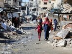 Palestinians walk past the ruins of houses destroyed during Israel's military offensive, amid the ongoing conflict between Israel and Hamas, in Gaza City, March 20, 2024.