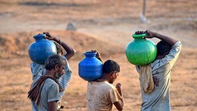 Chikkamagaluru: Residents carry pots after collecting drinking water amidst ongoing water crisis, in Chikkamagaluru, on Friday. (PTI)
