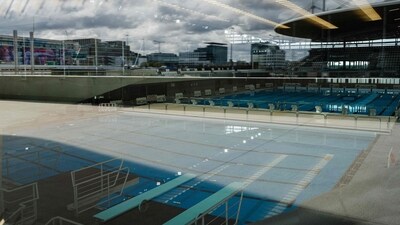 This photograph taken on March 28, 2024 via a window, shows swimming pools in the Aquatics Centre built for the Paris 2024 Olympic Games to be used for artistic swimming, diving and water polo competitions in Saint Denis, near Paris. VenhoevenCS & Ateliers 2/3/4/ designed the building. The Seine-Saint-Denis department north of Paris will host a number of events for the Paris 2024 Olympic and Paralympic Games, with venues including the Stade de France and Aquatics Centre, as well as the Olympic Village. (Photo by Dimitar DILKOFF / AFP) (AFP) This photograph taken on March 28, 2024 via a window, shows swimming pools in the Aquatics Centre built for the Paris 2024 Olympic Games to be used for artistic swimming, diving and water polo competitions in Saint Denis, near Paris. VenhoevenCS & Ateliers 2/3/4/ designed the building. The Seine-Saint-Denis department north of Paris will host a number of events for the Paris 2024 Olympic and Paralympic Games, with venues including the Stade de France and Aquatics Centre, as well as the Olympic Village. (Photo by Dimitar DILKOFF / AFP) (AFP)
