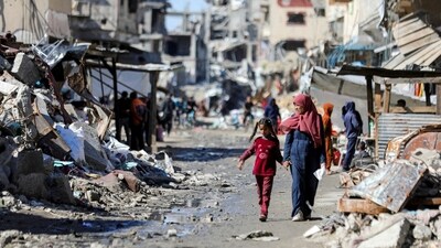Palestinians walk past the ruins of houses destroyed during Israel's military offensive, amid the ongoing conflict between Israel and Hamas, in Gaza City, March 20, 2024. (REUTERS)