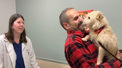 Mehrad Houman holds his dog, Mishka, after she was examined by the veterinarian. (AP)