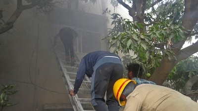 Firemen and others during a rescue operation after a fire broke out at the basement of a four-storey commercial building at RT Nagar in Bengaluru on Friday. (PTI) Firemen and others during a rescue operation after a fire broke out at the basement of a four-storey commercial building at RT Nagar in Bengaluru on Friday. (PTI)