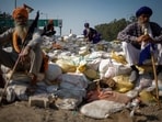 Farmers sit on a makeshift barricade of sand bags, at a protest site during the march towards New Delhi to push for better crop prices promised to them in 2021, at Shambhu Barrier, the border between Punjab and Haryana states, India February 23, 2024. REUTERS/Adnan Abidi