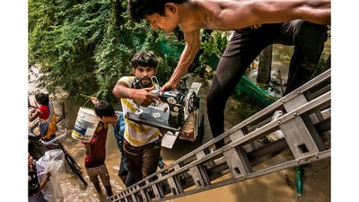 Residents carry their household goods and climb onto an under-construction overpass after being displaced in Saini nursery, Mayur Vihar, New Delhi on July 12, 2023. Many villages and farmlands were submerged in Delhi around the Yamuna river due to heavy rainfall and floods primarily caused by climate change. (Winning image in the Climate, Environment & Conservation category- single image). (Surender Solanki) Residents carry their household goods and climb onto an under-construction overpass after being displaced in Saini nursery, Mayur Vihar, New Delhi on July 12, 2023. Many villages and farmlands were submerged in Delhi around the Yamuna river due to heavy rainfall and floods primarily caused by climate change. (Winning image in the Climate, Environment & Conservation category- single image). (Surender Solanki)