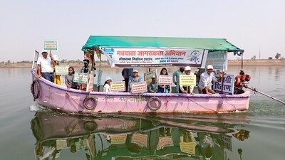 Administrators and officials hold placards while taking a boat ride in the Narmada River during the Voters Awareness campaign in Alirajpur, Madhya Pradesh. (ANI)
