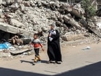 A woman and boy walk past the rubble of a collapsed building along a street in Rafah in the southern Gaza Strip A woman and boy walk past the rubble of a collapsed building along a street in Rafah in the southern Gaza Strip