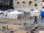 A man walks past tents and shacks erected by destroyed buildings in Rafah in the southern Gaza Strip