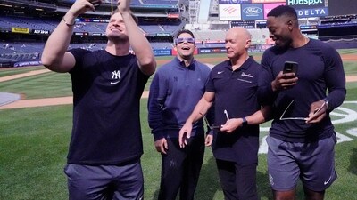 New York Yankees pitcher Clarke Schmidt attempts to get a picture of the solar eclipse by using his solar eclipse glasses and phone prior to the game against the Miami Marlins at Yankee Stadium. (Reuters)