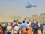 Rashtriya Janta Dal (RJD) supporters wave at party leader Tejashwi Yadav's helicopter as he leaves after addressing a public meeting at Rafiganj in Aurangabad district, Bihar.(PTI)