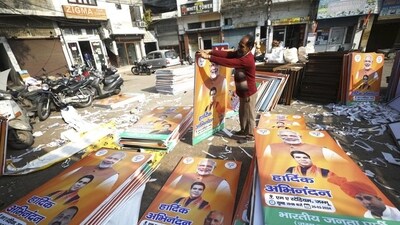 A worker arranging hoardings and posters. (File) A worker arranging hoardings and posters. (File)