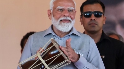 PM Narendra Modi tries his hands at playing a traditional drum during a public meeting ahead of the Lok Sabha polls in Rishikesh. (BJP) PM Narendra Modi tries his hands at playing a traditional drum during a public meeting ahead of the Lok Sabha polls in Rishikesh. (BJP)