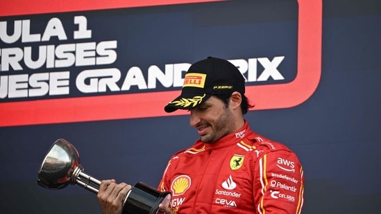 Ferrari's Spanish driver Carlos Sainz Jr holds his trophy on the podium (AFP)