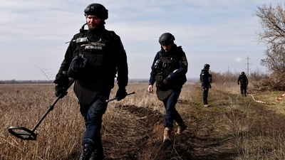 FILE PHOTO: Members of the de-mining department of the Ukrainian Emergency Services survey an area of farmland and electric power lines for land mines and other unexploded ordnance for electricians to access power towers damaged by Russian strikes in order to repair them, amid Russia's invasion of Ukraine, in Korovii Yar, in the Eastern Donetsk region, Ukraine, March 20, 2023. REUTERS/Violeta Santos Moura/File Photo (REUTERS)