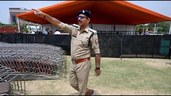 A Gautam Budh Nagar police officer checking security arrangement outside the venue where Home minister Amit Shah is set to address a public rally in Noida. (Sunil Ghosh/HT Photo)