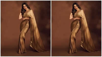 Mouni's saree comes in an alluring shade of gold and features a luxurious satin fabric adorned with an intricate gold sequin embroidered border. She draped it beautifully around her, letting the pallu fall elegantly from her shoulders and teamed it with a sleeveless brown blouse for a stunning look. (Instagram/@imouniroy) Mouni's saree comes in an alluring shade of gold and features a luxurious satin fabric adorned with an intricate gold sequin embroidered border. She draped it beautifully around her, letting the pallu fall elegantly from her shoulders and teamed it with a sleeveless brown blouse for a stunning look. (Instagram/@imouniroy)