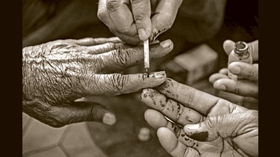 Bikaner: An election official marks the finger of a senior citizen with indelible ink, who casts his vote through postal ballot for the Lok Sabha elections, in Bikaner, Sunday, April 7, 2024. (PTI Photo)(PTI04_07_2024_000020A) (PTI) Bikaner: An election official marks the finger of a senior citizen with indelible ink, who casts his vote through postal ballot for the Lok Sabha elections, in Bikaner, Sunday, April 7, 2024. (PTI Photo)(PTI04_07_2024_000020A) (PTI)