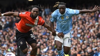 Luton Town's Fred Onyedinma, left, challenges for the ball with Manchester City's Jeremy Doku during the match between Manchester City and Luton Town at Etihad stadium in Manchester. (AP) Luton Town's Fred Onyedinma, left, challenges for the ball with Manchester City's Jeremy Doku during the match between Manchester City and Luton Town at Etihad stadium in Manchester. (AP)