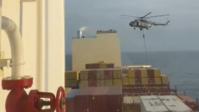 An official slides down a rope during a helicopter raid on MSC Aries ship. (via REUTERS)