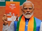 Prime Minister Narendra Modi displays a copy of the ruling Bharatiya Janata Party's (BJP) election manifesto for the general election. 