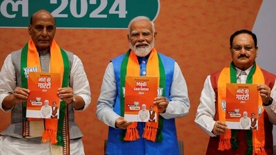 Indian Defence Minister Rajnath Singh, PM Narendra Modi and President of the Bharatiya Janata Party J. P. Nadda display copies of the ruling Bharatiya Janata Party's (BJP) election manifesto for the general election in New Delhi. (REUTERS)