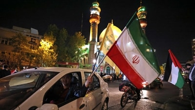 Iran-Israel conflict: Demonstrators wave Iran's flag and a Palestinian flag as they gather at Palestine Square in Tehran on April 14, 2024. (AFP) Iran-Israel conflict: Demonstrators wave Iran's flag and a Palestinian flag as they gather at Palestine Square in Tehran on April 14, 2024. (AFP)
