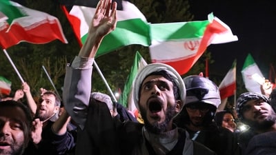 Demonstrators wave Iran's flag and Palestinian flags as they gather in front of the British embassy in Tehran on April 14, 2024, after Iran launched a drone and missile attack on Israel. (AFP) Demonstrators wave Iran's flag and Palestinian flags as they gather in front of the British embassy in Tehran on April 14, 2024, after Iran launched a drone and missile attack on Israel. (AFP)