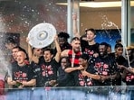 Leverkusen players celebrate with a makeshift trophy after Bayer Leverkusen won the German Bundesliga title, beating Werder Bremen in Leverkusen