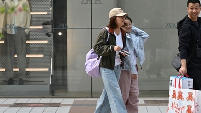 China unhappy leave: A man carries shopping bags as he walks with a woman and child along a retail district in Beijing. (AFP) China unhappy leave: A man carries shopping bags as he walks with a woman and child along a retail district in Beijing. (AFP)