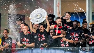 Leverkusen players celebrate with a makeshift trophy after Bayer Leverkusen won the German Bundesliga title, beating Werder Bremen in Leverkusen (AP)