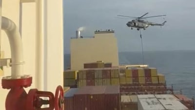 An official slides down a rope during a helicopter raid on MSC Aries ship. (via REUTERS)