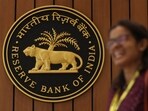 A woman walks past the Reserve Bank of India (RBI) logo inside its headquarters in Mumbai, India.