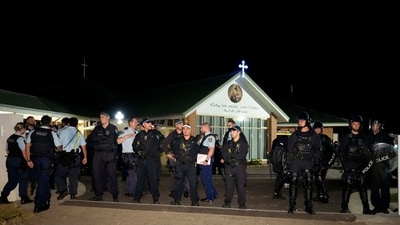 Security officers stand guard outside Orthodox Assyrian church in Sydney, Australia after a bishop and churchgoers were stabbed in the church. (AP) Security officers stand guard outside Orthodox Assyrian church in Sydney, Australia after a bishop and churchgoers were stabbed in the church. (AP)