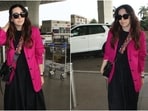 Karisma Kapoor in a midi dress, hot pink blazer and a no-makeup look poses for the paparazzi at the airport. 