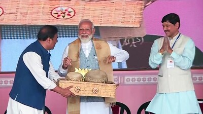Prime Minister Narendra Modi tries his hands on playing a traditional instrument during a public meeting in support of Asom Gana Parishad (AGP) candidate Phani Bhusan Choudhury for the upcoming Lok Sabha polls in Nalbari on Wednesday. (ANI)