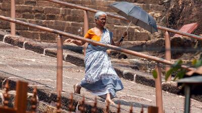 An elderly woman walks with an umbrella to protect herself from the heat in eastern India. (ANI Photo) An elderly woman walks with an umbrella to protect herself from the heat in eastern India. (ANI Photo)