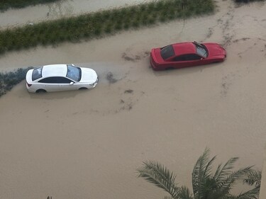 Cars are parked at a flooded street during a rain storm in Dubai, United Arab Emirates, on April 16. (REUTERS)