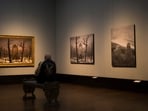 A man sits in front of a copy of Caspa David Friedrich's painting Monastery Cemetery In Snow' during a press preview of the exhibition 'Caspar David Friedrich. 