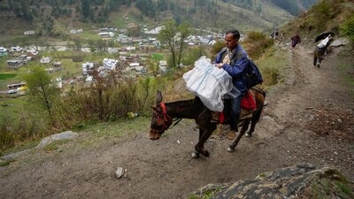 An election official sits on a horse holding EVMs as he heads to a polling booth in a remote mountain area at Dessa village, Doda district, Jammu and Kashmir. (AP) An election official sits on a horse holding EVMs as he heads to a polling booth in a remote mountain area at Dessa village, Doda district, Jammu and Kashmir. (AP)