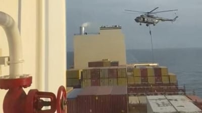 An official slides down a rope during a helicopter raid on MSC Aries ship at sea in this screen grab obtained from a social media video released on April 13 (via REUTERS) An official slides down a rope during a helicopter raid on MSC Aries ship at sea in this screen grab obtained from a social media video released on April 13 (via REUTERS)