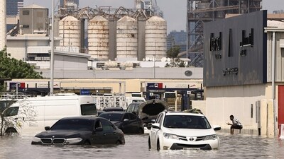 A person sits near vehicles stranded in flood water caused by heavy rains in Dubai, United Arab Emirates, April 17, 2024. (Reuters)