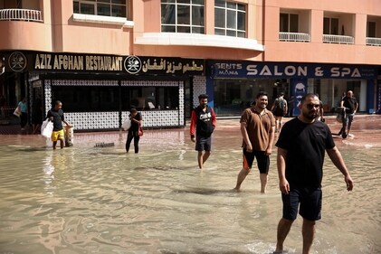 People walk through flood water caused by heavy rains, in Dubai, United Arab Emirates, April 17, 2024. (REUTERS)