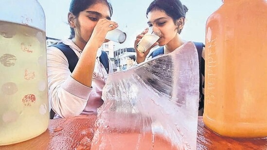 Girls cooling off with an iced drink near Masunda Lake in Thane as mercury dipped by five degrees Celsius after two days of scorching heat in Mumbai (Praful Gangurda/HT Photo)