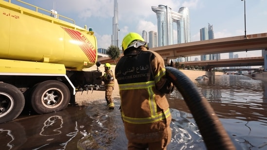 Members of the Dubai Civil Defence use a bowser to remove water from a flooded highway after a rainstorm in Dubai, United Arab Emirates.&nbsp;(Bloomberg)