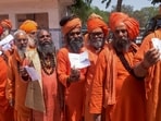 Hindu holymen in saffron robes queue up to cast their votes during the first round of voting of India's national election in Haridwar, India, Friday, April 19, 2024. (AP Photo/Sandeep Sharma)