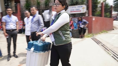 Presiding Officer Neichutuonuo Yhome, 27, seen carrying an Electronic Voting Machine (EVM) towards her polling station on the eve of polls, in Kohima, Nagaland. (Yirmiyan Arthur / AP)