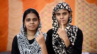 Women show their inked finger after casting their vote at a polling station, in Chennai, Tamil Nadu. (R. Satish Babu / AFP)
