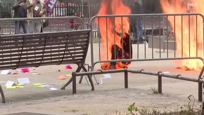 A person is covered in flames outside the courthouse where former U.S. President Donald Trump's criminal hush money trial is underway, in New York, U.S., April 19, 2024 in this screen grab taken from a pool video. Reuters TV via REUTERS (via REUTERS)