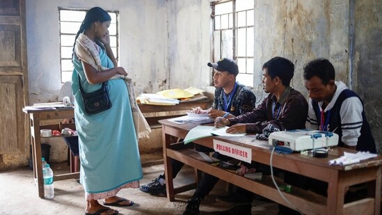 A pregnant woman waits to get her voter slip from polling officers to cast her vote at a remote polling station in Nongriat village, during the first phase of the election, in Shillong in the northeastern state of Meghalaya.(REUTERS)